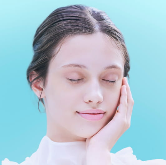 女性が手を頬に押し当てて、化粧水をつけている画像